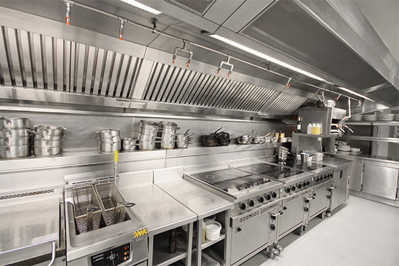 Stainless steel commercial kitchen with extraction canopy and appliances