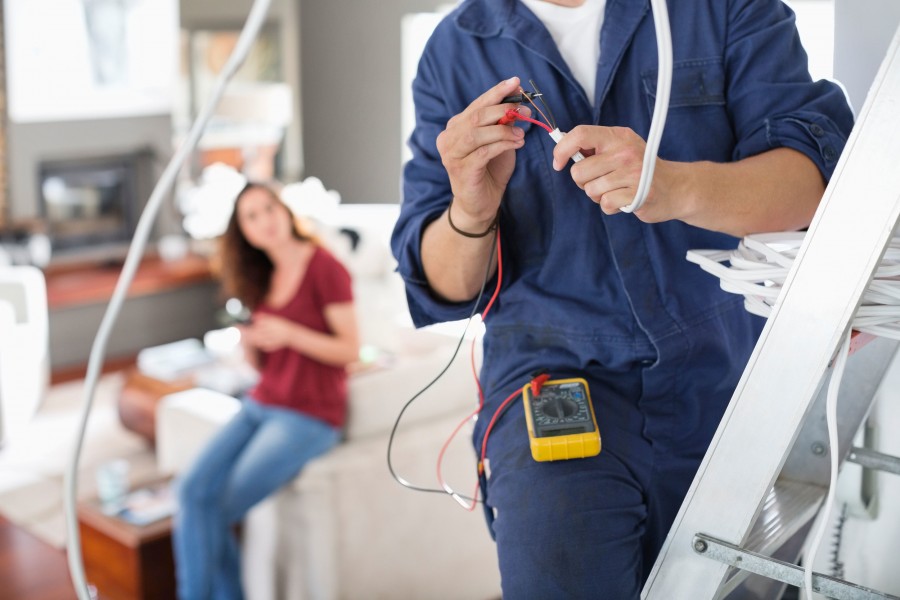 SES electrician wiring a light fitting in a customer&rsquo;s home